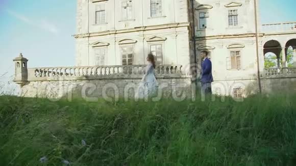新婚夫妇在古堡附近散步新娘旋转视频的预览图