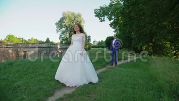 新婚夫妇在古堡附近散步新娘旋转视频的预览图