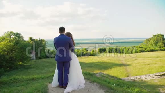 可爱的新婚夫妇站在美丽的大自然上视频的预览图