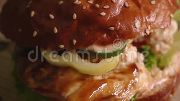 汉堡和炸鸡肉放在西红柿黄瓜和生菜上慢动作视频的预览图