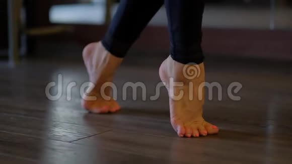 女舞者美丽光脚脚尖小心踩在地上芭蕾舞棒近景慢动作视频的预览图