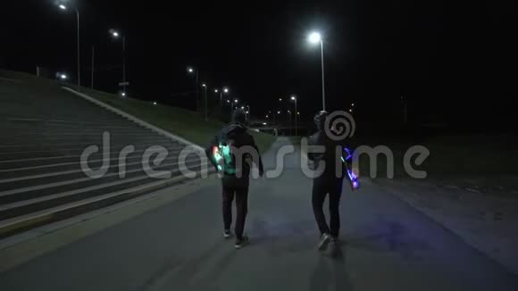 曼斯走在夜晚的街道上有照明的长板视频的预览图