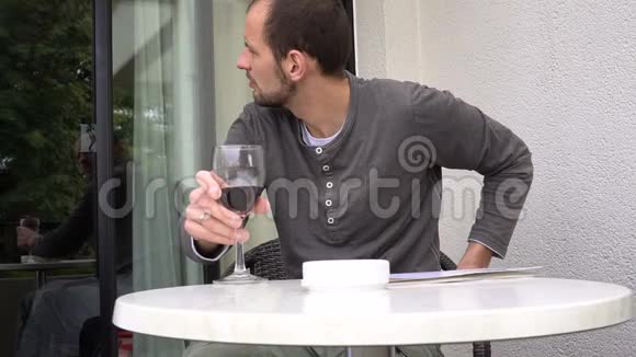英俊的男人手里拿着杂志喝着一杯好酒视频的预览图