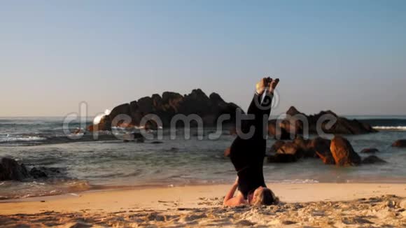 早上穿黑色运动服的女士在海边冥想视频的预览图