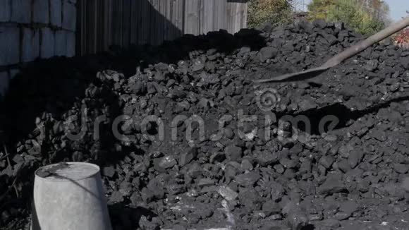人拿着铲子在后院堆煤私人住宅用煤加热为冬天做准备慢慢慢慢视频的预览图