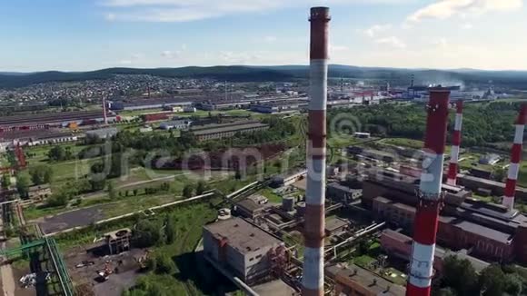 在一个阳光明媚的夏天为工厂烟囱和城市景观提供空中服务录像蓝色城市工业区视频的预览图