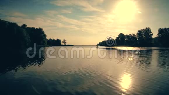 在一条宽阔的河中一个渔夫钓到了一条船明媚的阳光照在蓝天上视频的预览图