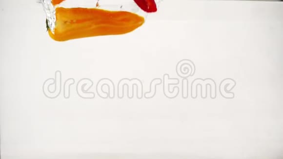 红椒和橙椒随着飞溅和气泡落入水中慢动作特写镜头视频的预览图