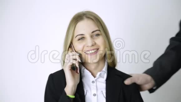 女商人在打电话时雇员做了很长时间的工作后会按摩她的肩膀和脖子视频的预览图