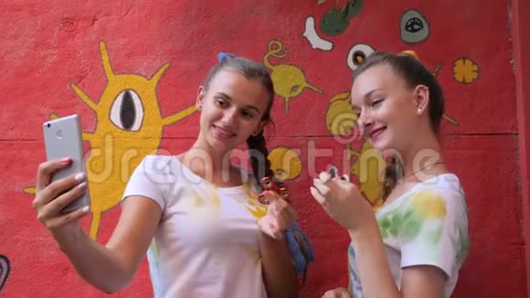 两个女孩玩旋转在手机上拍照朋友玩玩具缓解压力自拍视频的预览图