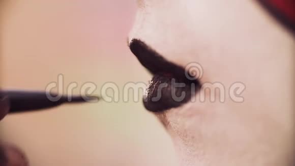 化妆师在嘴唇上涂上黑色视频的预览图