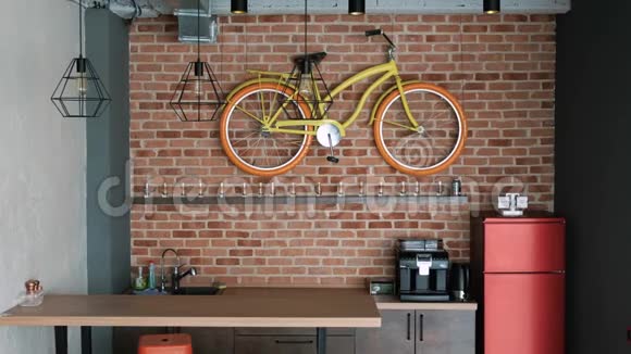 一个真正的现代室内阁楼风格厨房里有一个酒吧一个冰箱和一辆装饰自行车视频的预览图