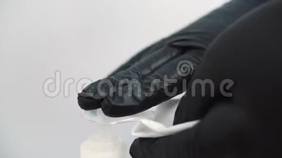 美容师用玻璃碟子从管子里挤出奶油双手戴着医用手套女人从一个视频的预览图