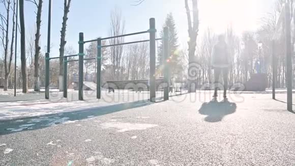 低角度对抗太阳运动女孩在冬天的操场上做弓步大步向前视频的预览图