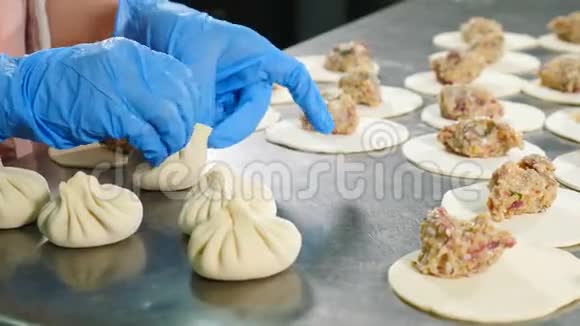 在肉厂做肉饺子女工戴白色乳胶手套统一用面团包肉肉类厂视频的预览图