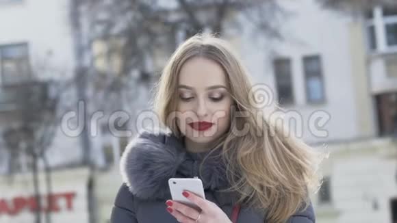 快乐女孩在电话里说着笑在冬天的街道上视频的预览图