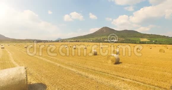 在阳光明媚的乡村里用一捆干草拍摄麦田的空中景色美丽的山景视频的预览图