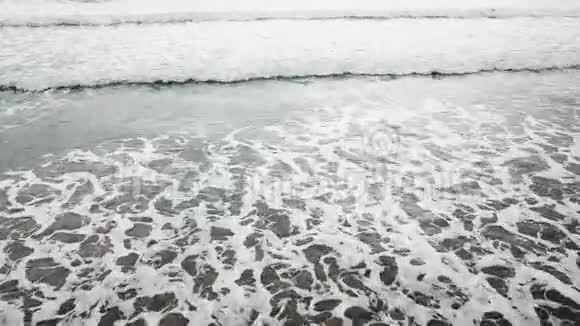 鸟瞰海洋蓝绿波浪在白沙滩上破碎美丽的海滩上的海浪鸟瞰无人机4k视频的预览图