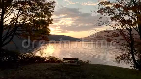 一个宁静的城市公园靠近海洋日出时有一个孤独的公园长凳视频的预览图