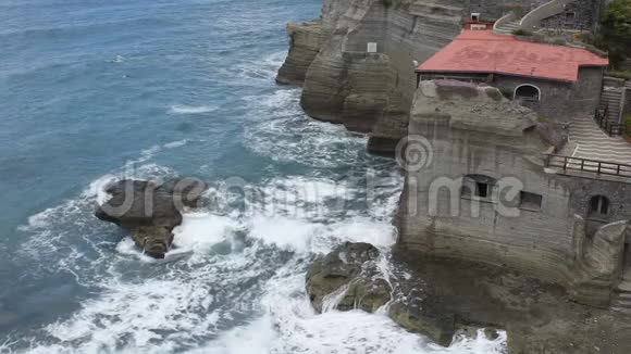 波浪在岩石峭壁上翻滚里面雕刻着古老的石头建筑视频的预览图