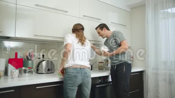 快乐的一对夫妇一起在家煮健康的食物视频的预览图