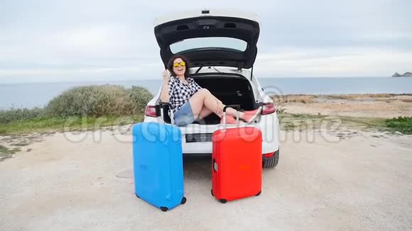 快乐的女旅行者在她的车旁边放着手提箱视频的预览图