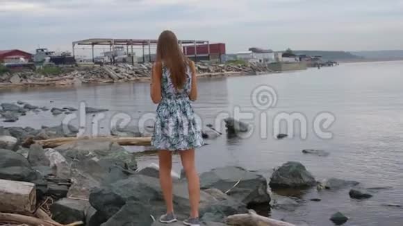 女孩沿着石头沿着海岸走视频的预览图