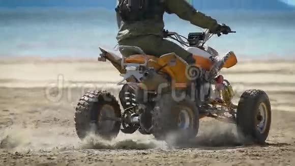 海滩在电视上的那个人赛车手在ATV上的沙滩上做环形交叉ATV的特点是轮胎很大很高视频的预览图