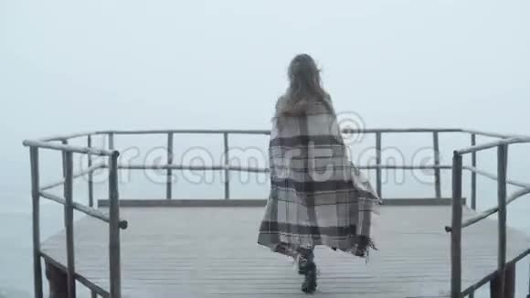 年轻女子站在木墩上远远望着她的背影女性在雾天独处视频的预览图
