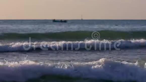 海波浪沙滩上美丽的日出渔船和海上渔民视频的预览图