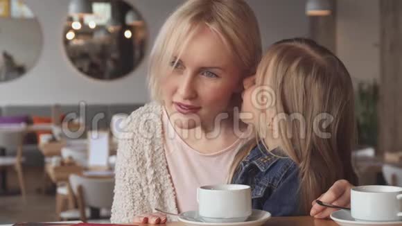 小女孩在咖啡馆妈妈耳边低语视频的预览图