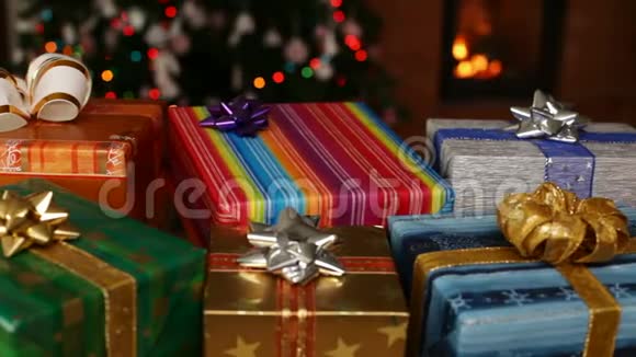壁炉前的许多圣诞礼物和圣诞树上模糊的灯光视频的预览图