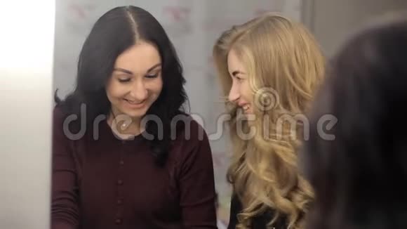 两个女人看关于美的杂志视频的预览图