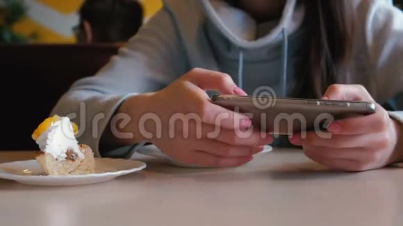 面目全非的女人坐在咖啡馆里玩手机双手特写视频的预览图