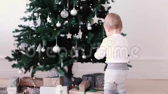 小男孩看圣诞树上的玩具视频的预览图
