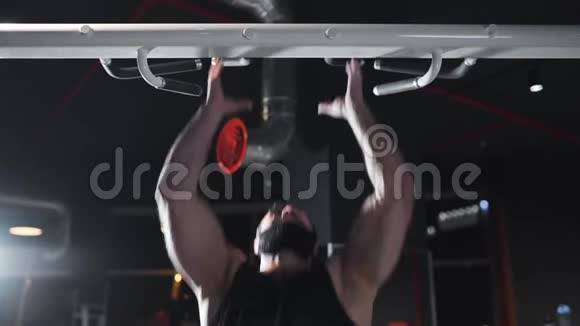强壮的人在健身房锻炼肌肉在模拟器上做力量练习在水平杆上做拉力练习在运动视频的预览图