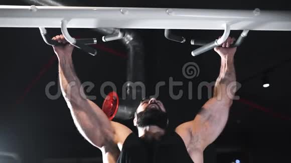 强壮的人在健身房锻炼肌肉在模拟器上做力量练习在水平杆上做拉力练习在运动视频的预览图