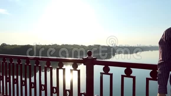 斯隆莫夕阳下一座桥的扶手旁站着微笑视频的预览图