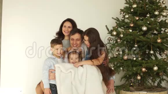 圣诞树附近父母和三个孩子的家庭肖像圣诞快乐新年快乐孩子是视频的预览图