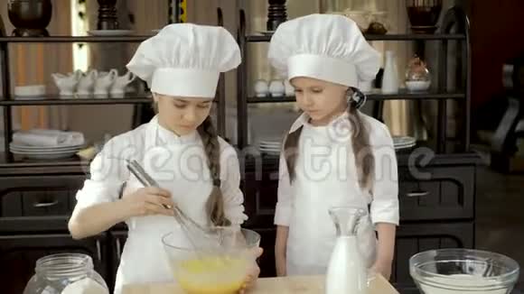 小女孩用玻璃碗在木桌上打鸡蛋视频的预览图