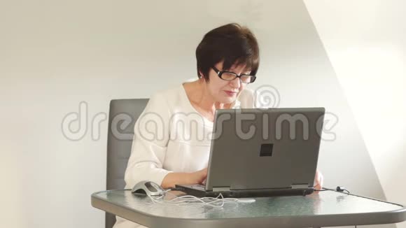 一位中年妇女正集中精力在电脑上工作她对工作充满热情自言自语视频的预览图