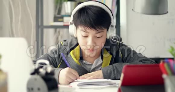 年轻的亚洲青少年学生在家听音乐和做作业多莉在视频的预览图