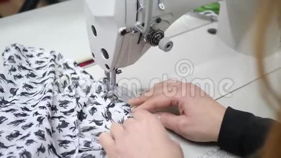 纺织业裁缝的助手在工作室的缝纫机上修理衣服视频的预览图