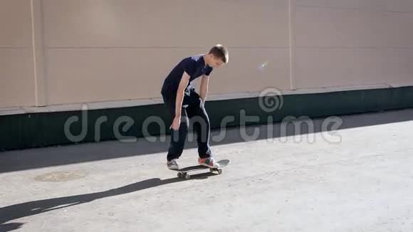 一个年轻的滑板手热爱街头风格跳上滑板以表演最古老的技巧踢腿视频的预览图