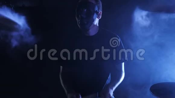 这部带有男鼓手面具的史诗镜头被烟雾围绕在一个缓慢运动的鼓上演奏音乐剧视频的预览图