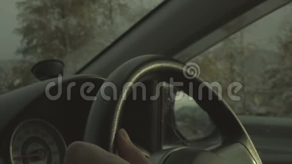 在夕阳下缓慢行驶的冬季景观中驾驶汽车关闭方向盘视频的预览图