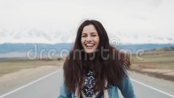美丽的少女潮人在山上的背景下在路上跳舞我快乐和快乐牛仔裤夹克视频的预览图