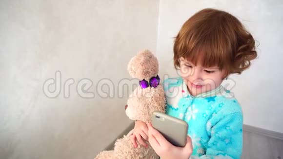 开朗的小女孩在妈妈的电话做表情视频的预览图