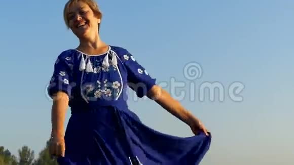 一个微笑的女人在夏天飘扬她的裙子视频的预览图