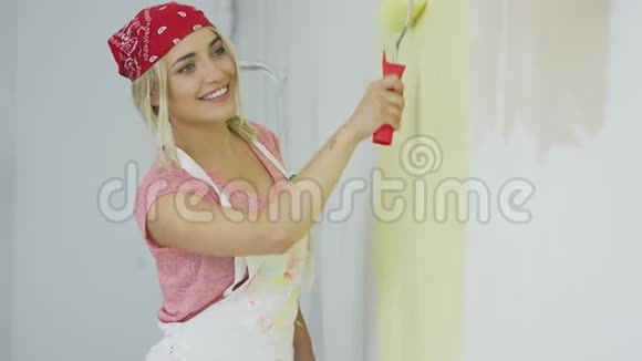 微笑女性用滚筒画墙视频的预览图